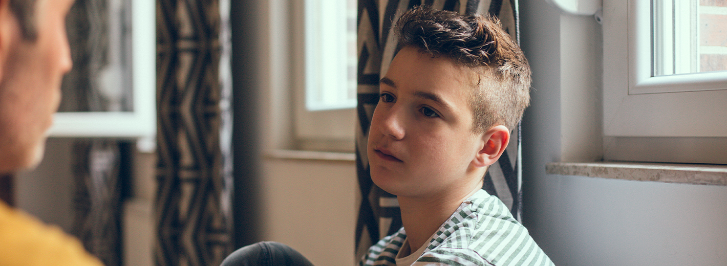 Jeune garçon triste qui parle à un adulte