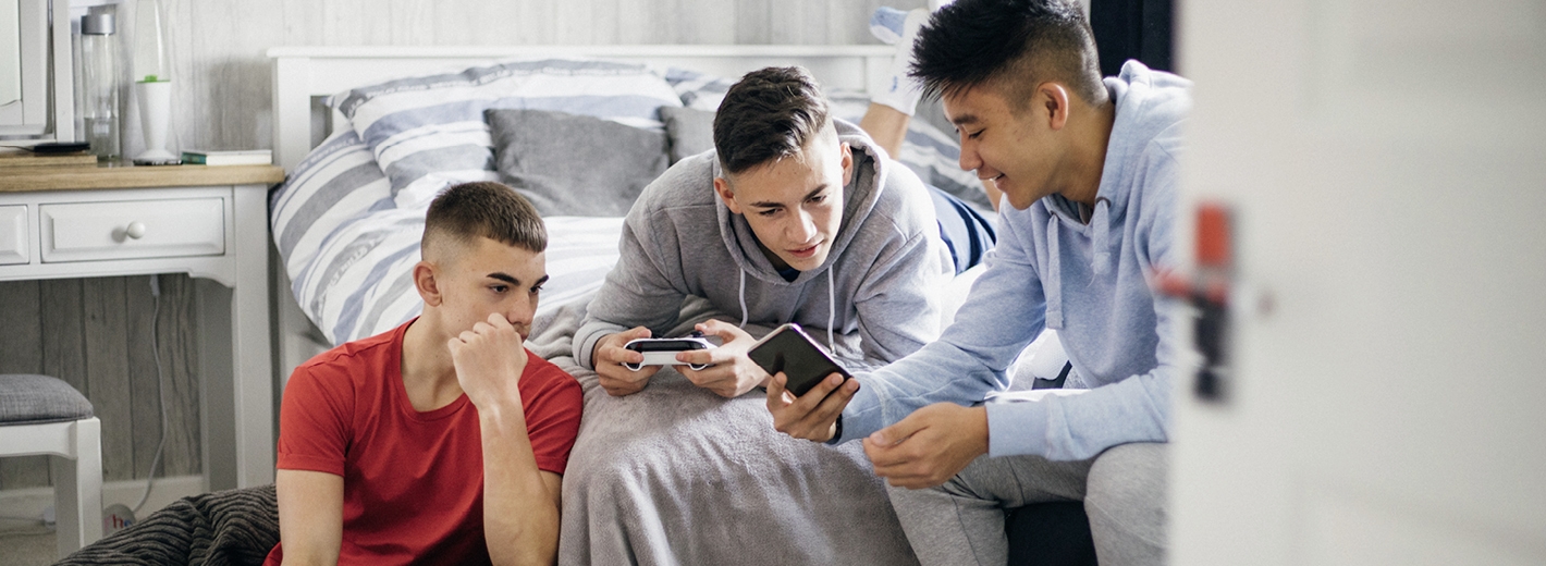 Trois garçons regardant un téléphone