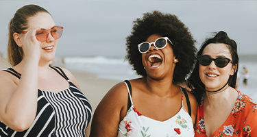 Trois filles sur la plage en train de rire