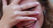 Jeune fille qui sourit avec la main sur son visage