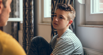 Jeune garçon triste qui parle à un adulte