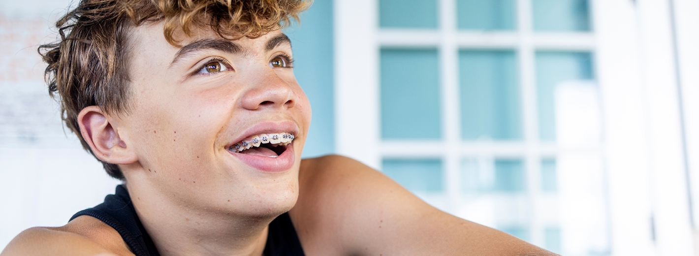Jeune garçon avec un appareil dentaire souriant en gros plan
