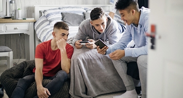 Trois garçons regardant un téléphone
