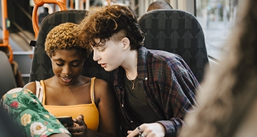 Deux jeunes regardant un téléphone dans un bus