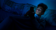 Jeune garçon sur son téléphone dans son lit