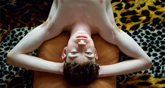 Jeune garçon allongé sur le sol les bras croisés