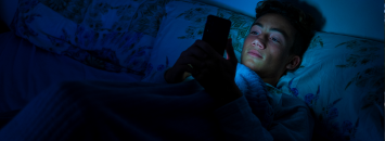 Jeune garçon sur son téléphone dans son lit