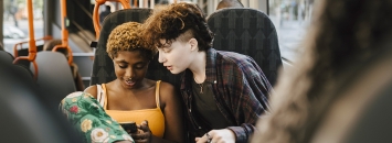 Deux jeunes regardant un téléphone dans un bus